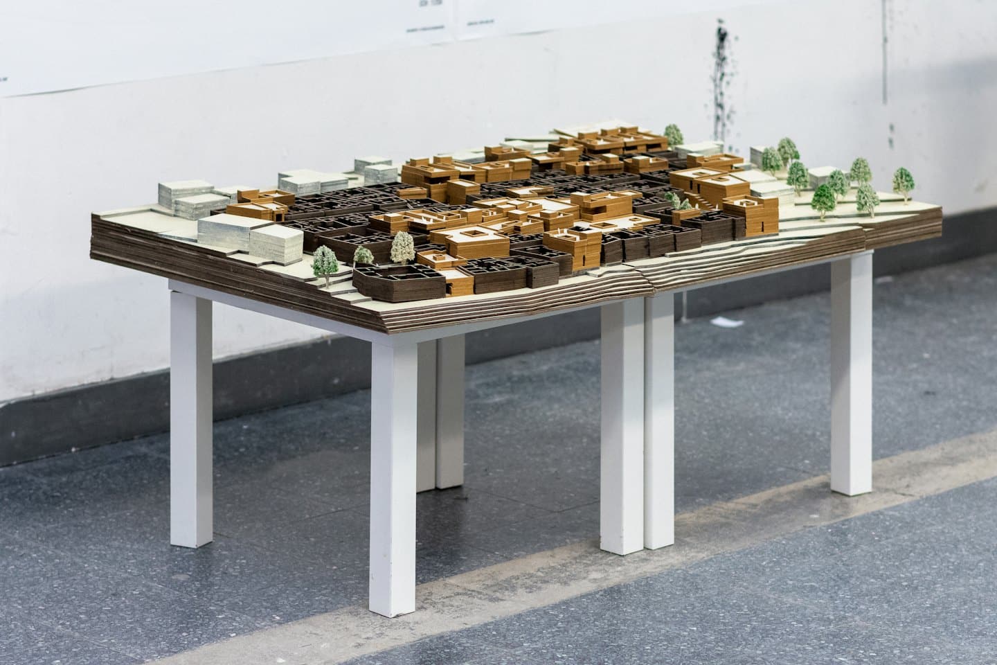 Architectural model of a town with brown buildings and green trees.
